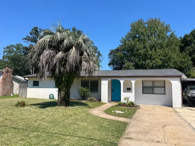 a front view of house with yard and trees around