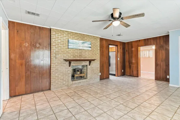 a view of an empty room with a ceiling fan and window