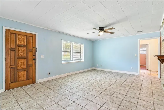 an empty room with fan and windows