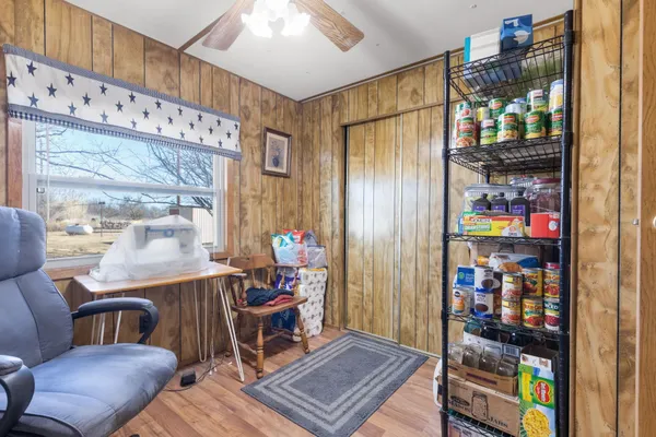 a living room with furniture a bookshelf and a window