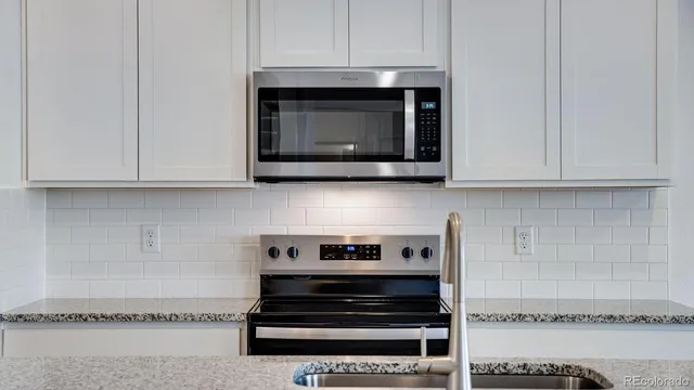 a stove top oven sitting inside of a kitchen
