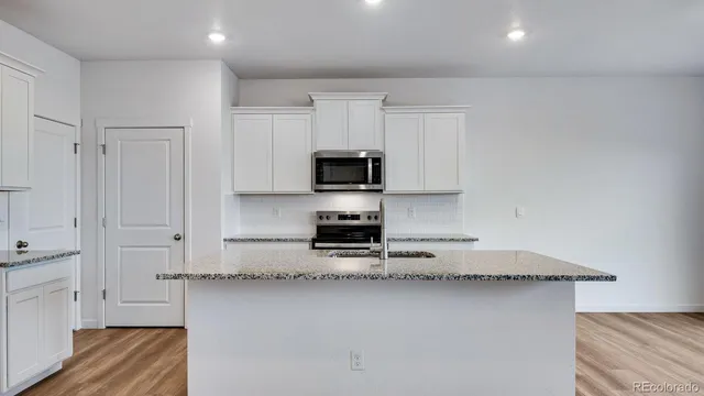 a kitchen with a refrigerator and a stove top oven