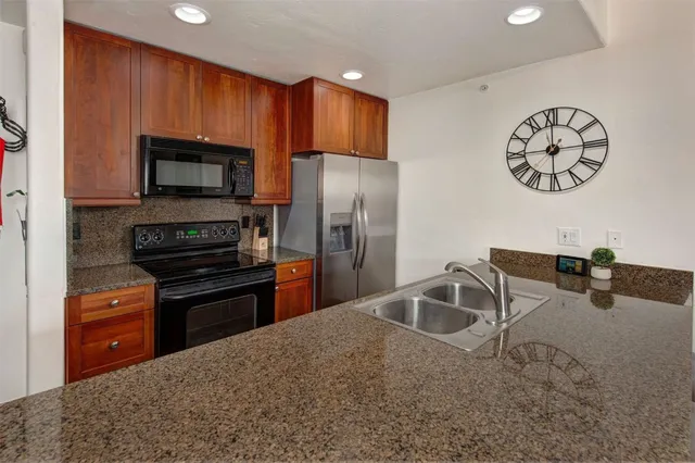 a kitchen with stainless steel appliances granite countertop a refrigerator stove and microwave