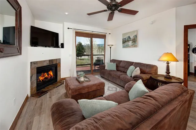 a living room with furniture a fireplace and a flat screen tv