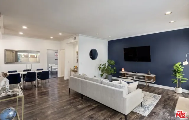 a living room with furniture potted plant and a flat screen tv