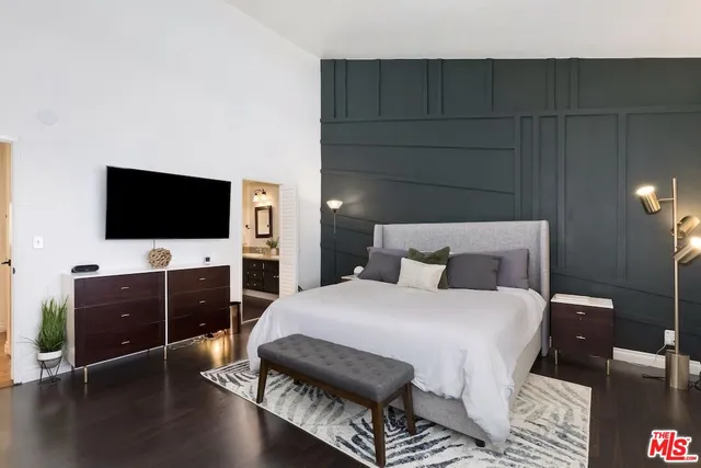 a bedroom with a bed and a flat screen tv