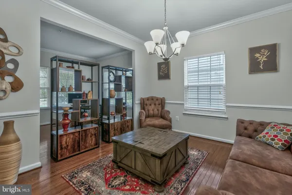 a living room with furniture a chandelier and a window