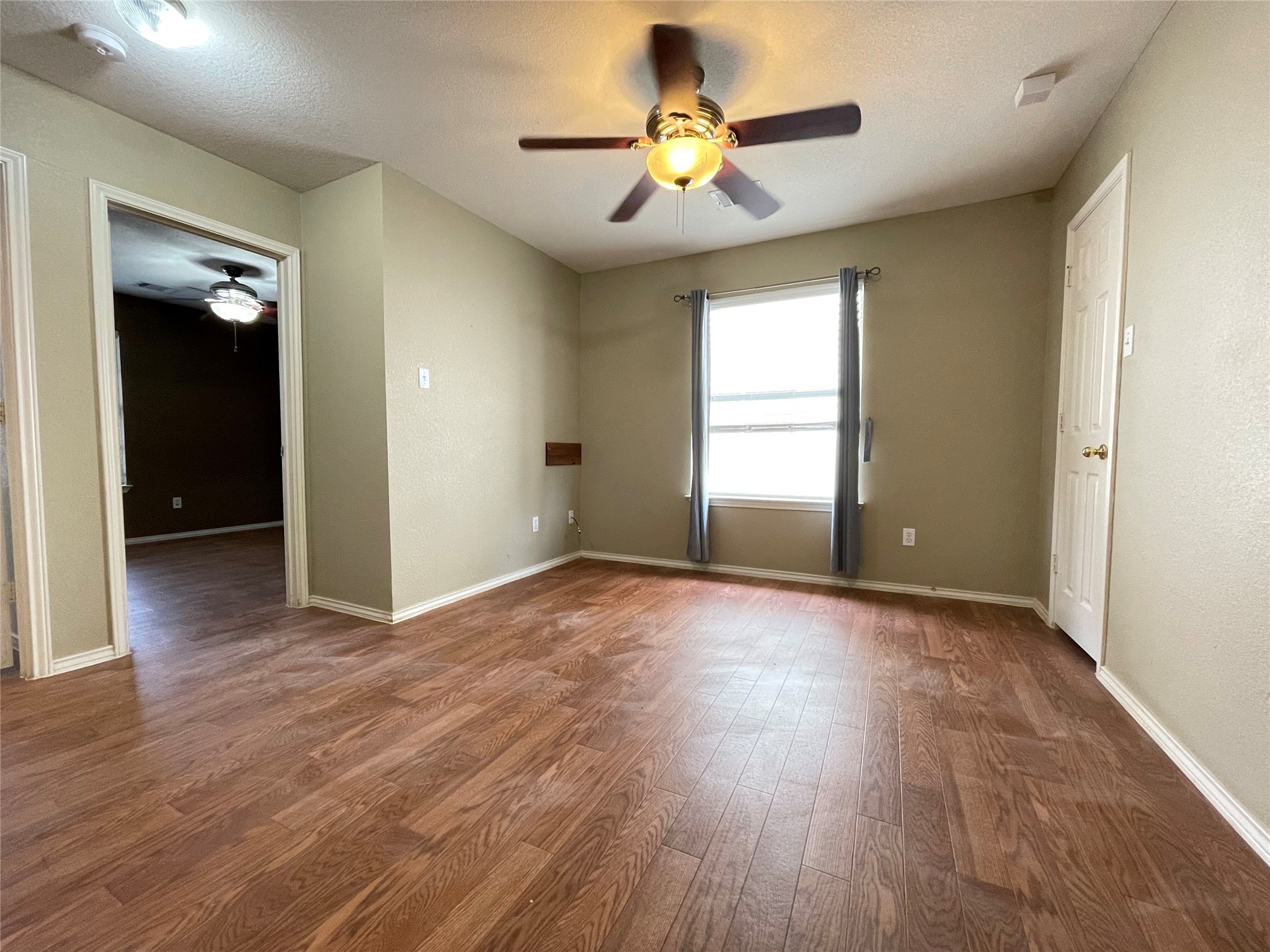 3638 Windhill Loop Round Rock, TX 78681 - Photo 17 of 32 Room featuring wood-finish flooring, a ceiling fan with integrated lighting, and a window with gray curtains