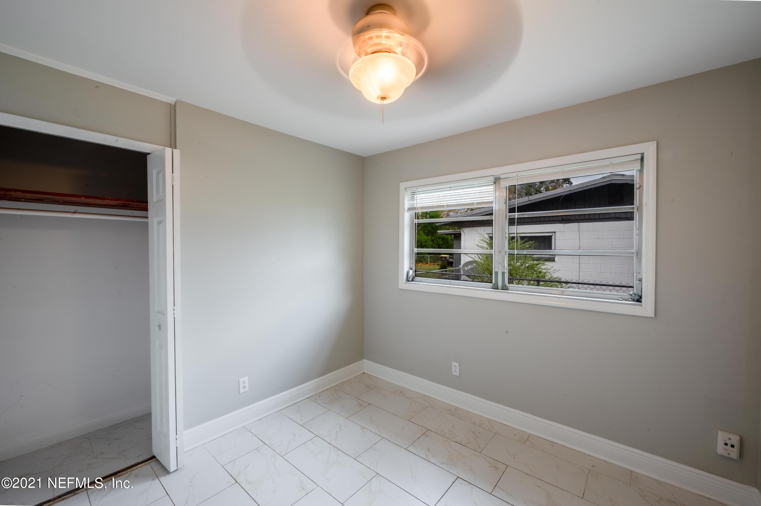 7521 Strato Road Jacksonville, FL 32210 - Photo 15 of 40 a view of an empty room with window and chandelier fan