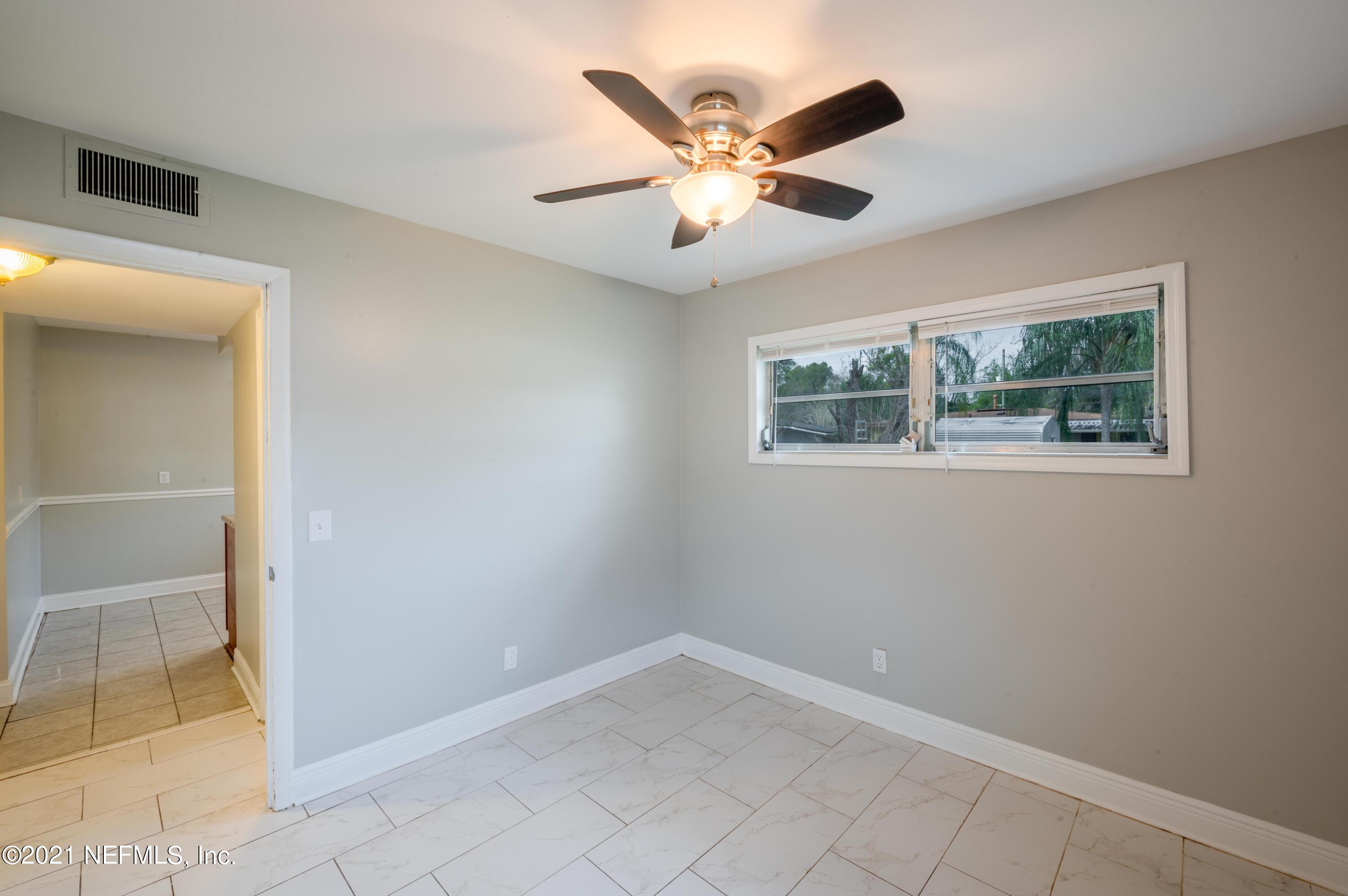 7521 Strato Road Jacksonville, FL 32210 - Photo 18 of 40 an empty room with windows and fan