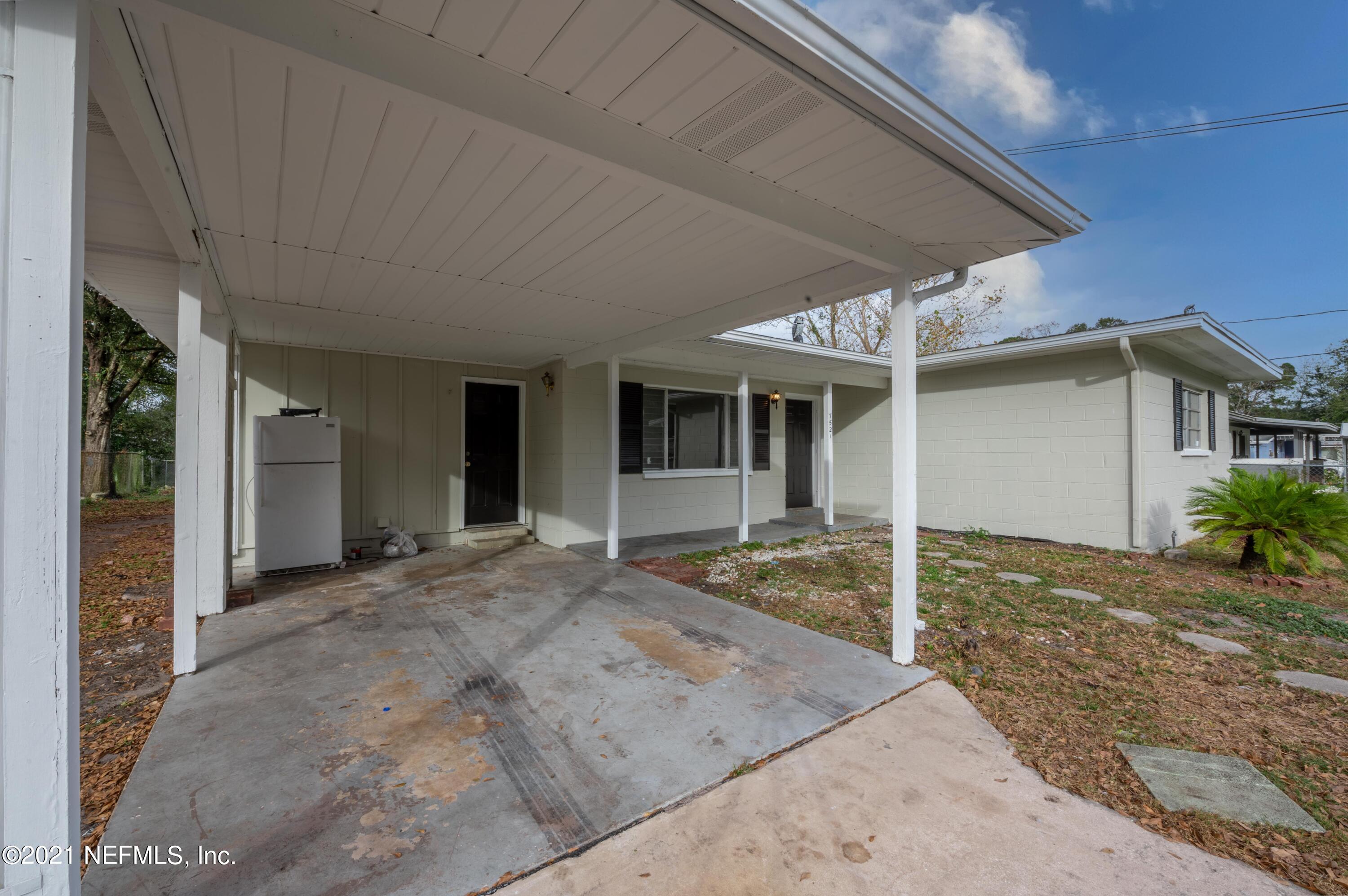 7521 Strato Road Jacksonville, FL 32210 - Photo 40 of 40 a front view of a house with a floor to ceiling window and potted plants