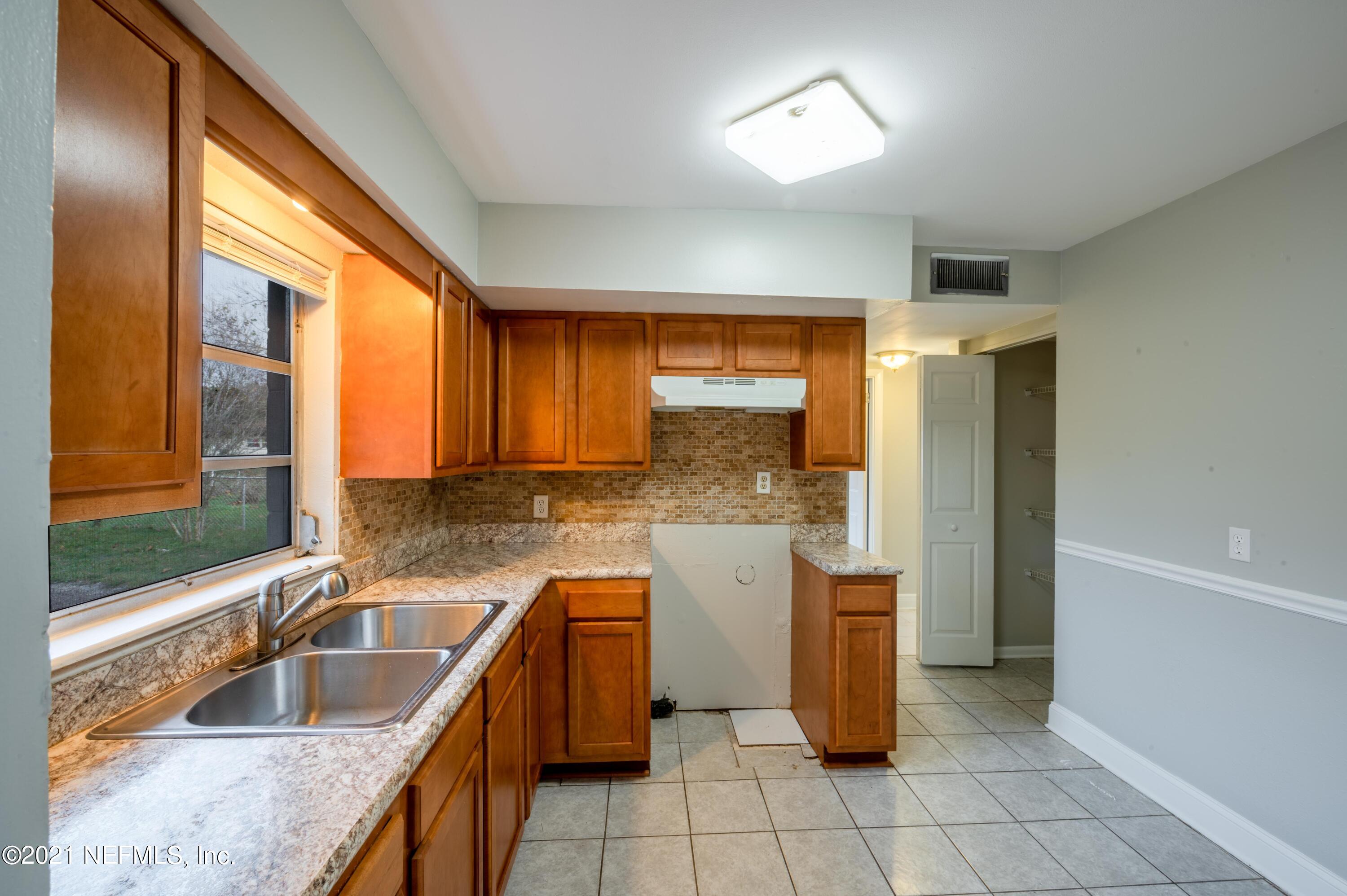 7521 Strato Road Jacksonville, FL 32210 - Photo 6 of 40 a kitchen with a sink a counter top space and cabinets