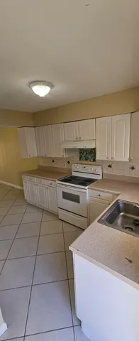 a kitchen with cabinets and white stainless steel appliances