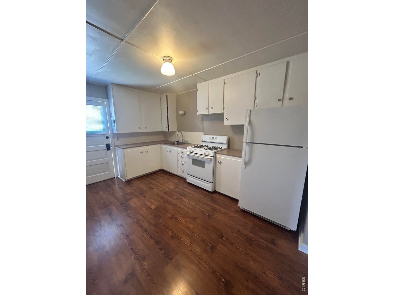 516 South Meldrum Street Fort Collins, CO 80521 - Photo 11 of 15 a kitchen with a refrigerator and white cabinets