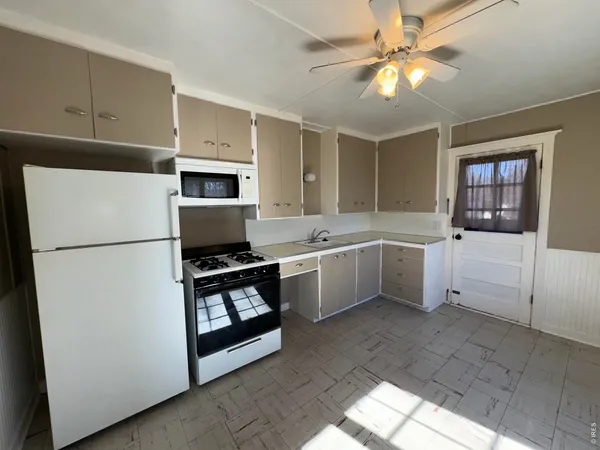 a kitchen with a refrigerator sink and cabinets