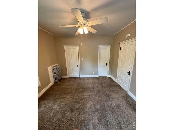 a view of a livingroom with a ceiling fan and window