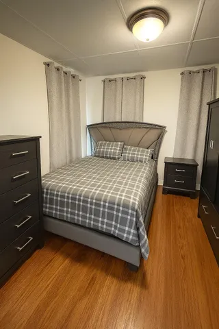 a bedroom with a bed and wooden floor