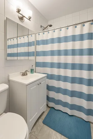 a bathroom with a sink a toilet a shower and a mirror