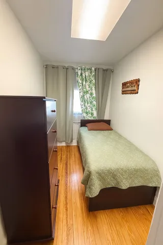 a bed sitting in a bedroom next to a window