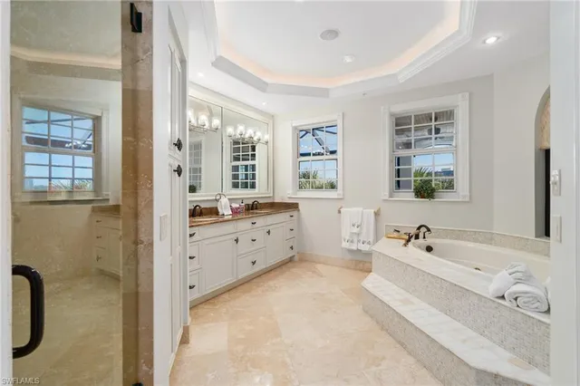 a spacious bathroom with a granite countertop tub a double vanity sink and a mirror