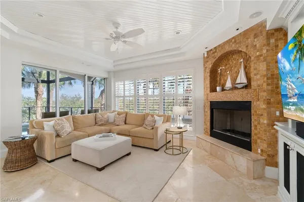 a living room with furniture a fireplace and a large window