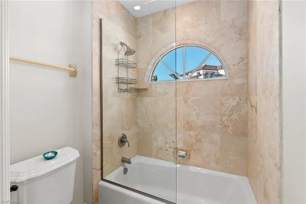 a bathroom with a granite countertop sink a toilet and bathtub