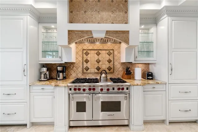 a large kitchen with stainless steel appliances granite countertop a stove and a sink