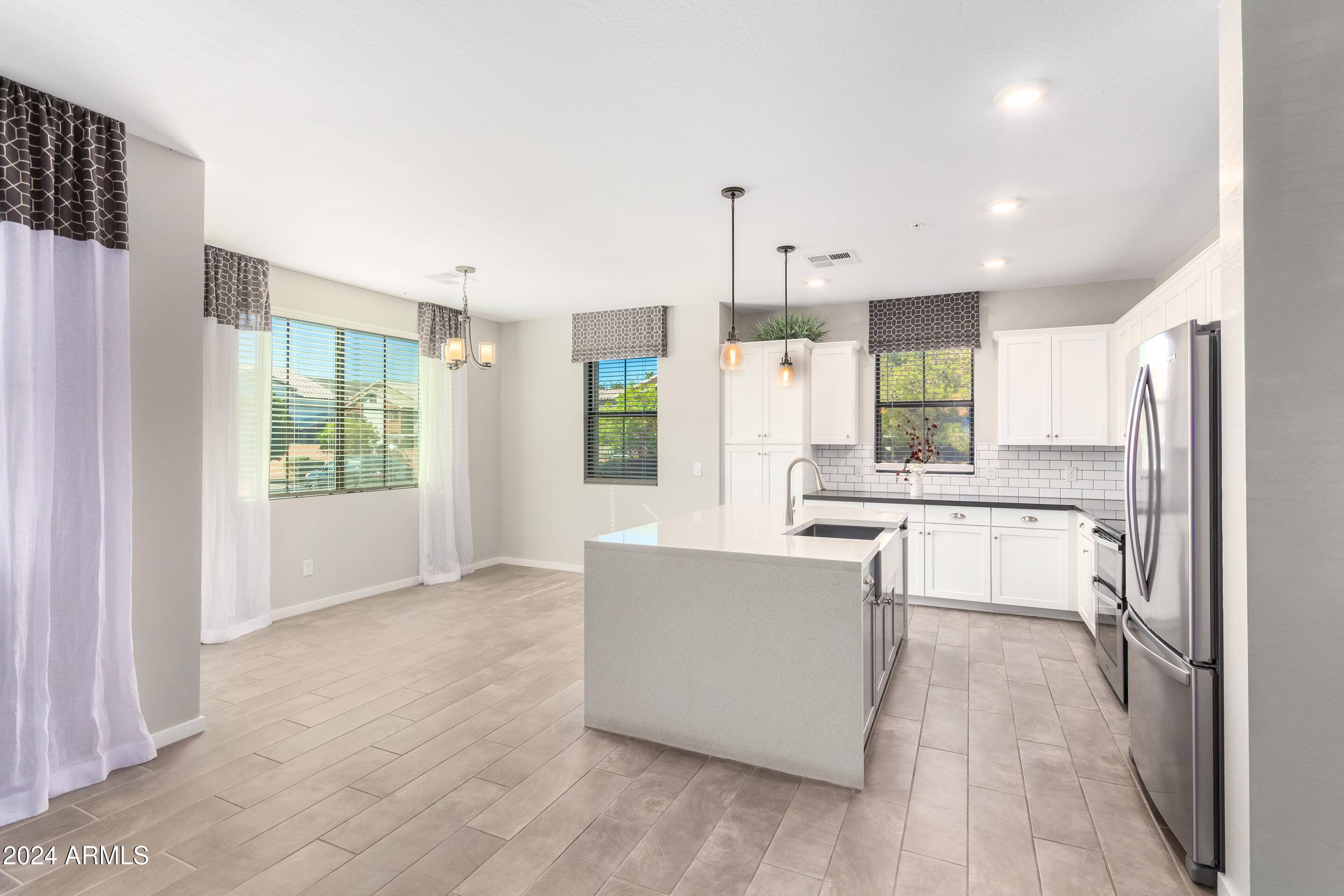 3900 East Baseline Road, Unit 177 Phoenix, AZ 85042 - Photo 11 of 41 a large kitchen with kitchen island a large counter top space a sink stainless steel appliances and cabinets