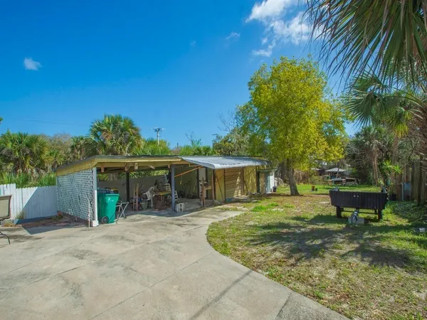 a view of a backyard with table and chairs plants and trees