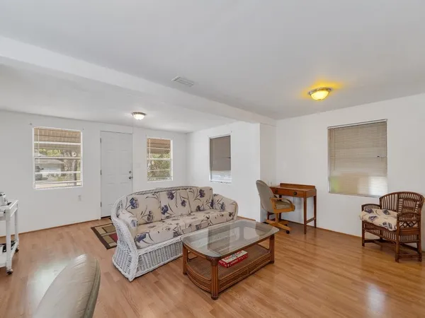 a living room with furniture a desk and chair with wooden floor
