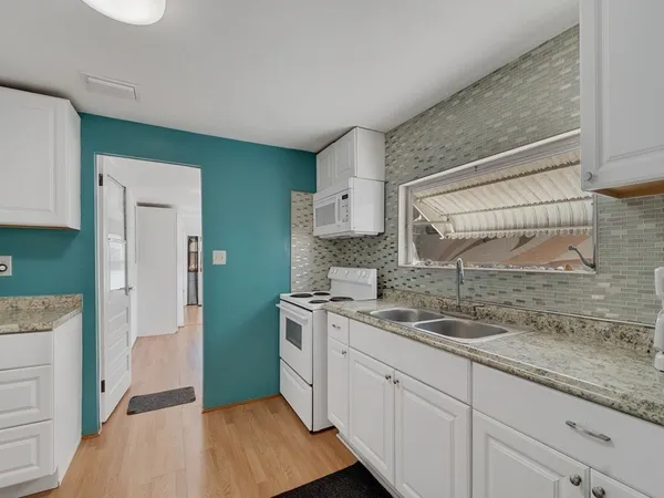a kitchen with a refrigerator sink and cabinets