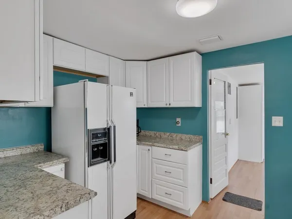 a kitchen with white cabinets and white appliances