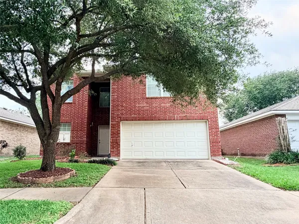 a front view of a house with a yard and a garage