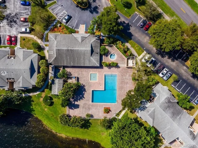 a view of swimming pool with seating space and trees in the background