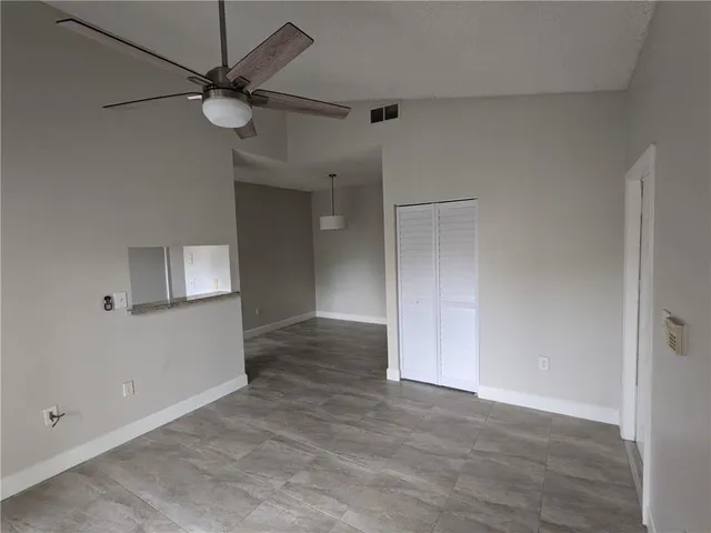 an empty room with fan and entrance