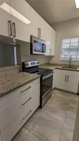 a kitchen with stainless steel appliances granite countertop a sink and a stove