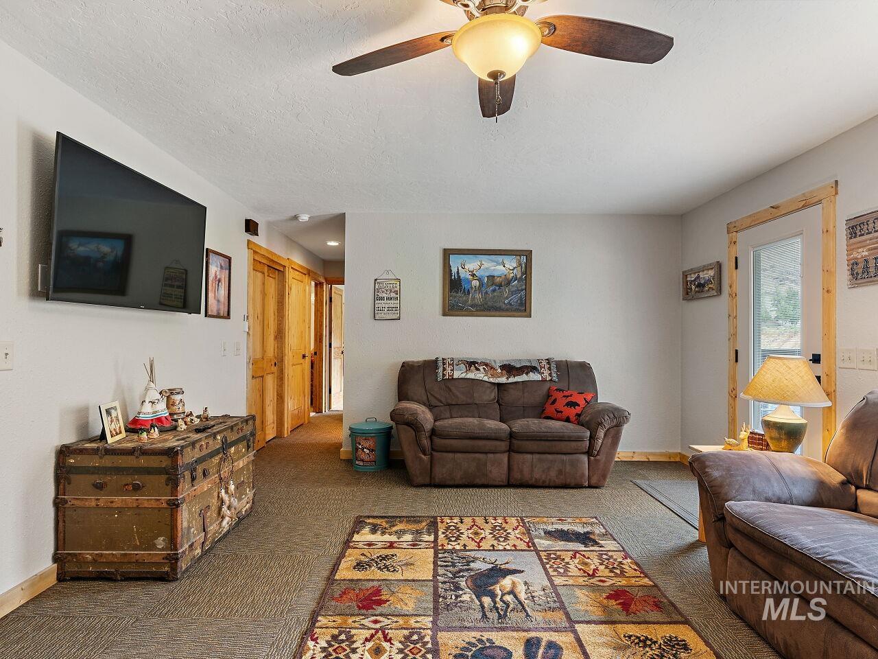 7438 Highway 95 Riggins, ID 83549 - Photo 21 of 36 Living room with carpet floors, a ceiling fan, and a textured ceiling