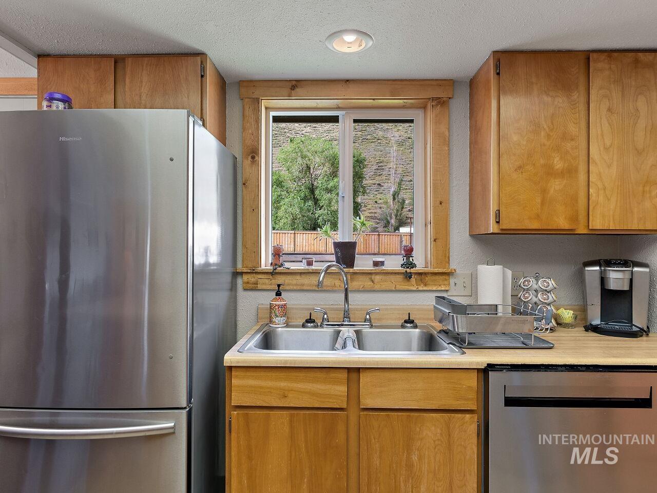 7438 Highway 95 Riggins, ID 83549 - Photo 26 of 36 Kitchen with stainless steel appliances, light countertops, a textured ceiling, and wood finish cabinets