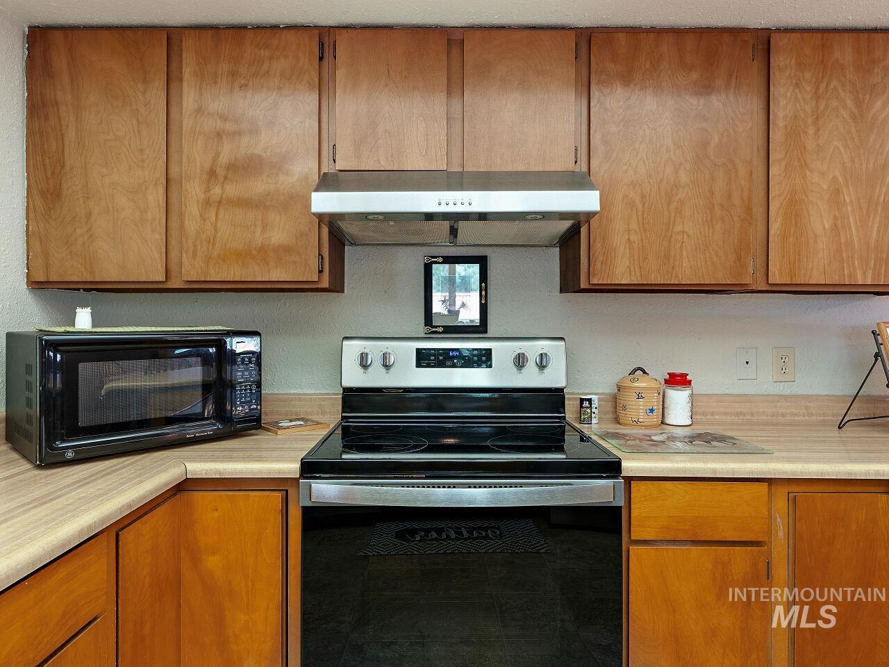 7438 Highway 95 Riggins, ID 83549 - Photo 27 of 36 Kitchen with stainless steel electric range oven, light countertops, and wood finish cabinetry