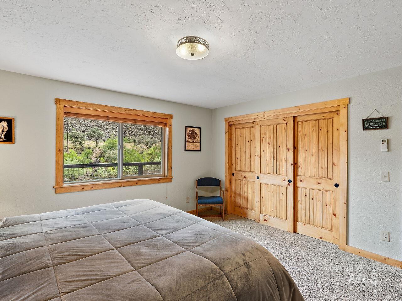 7438 Highway 95 Riggins, ID 83549 - Photo 32 of 36 Bedroom with a closet, carpet floors, and a textured ceiling