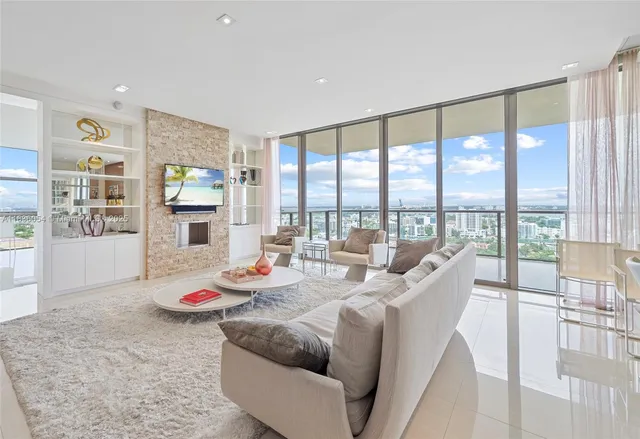 a living room with furniture and floor to ceiling windows