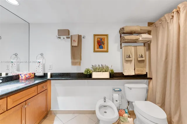 a bathroom with a granite countertop sink mirror vanity and toilet