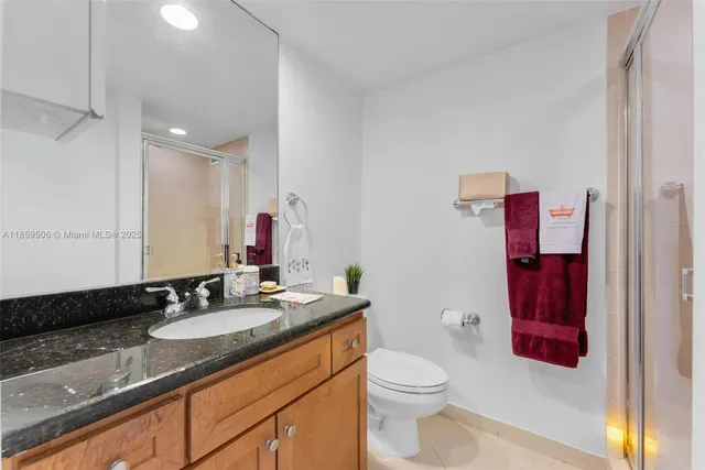 a bathroom with a granite countertop sink a toilet and a shower