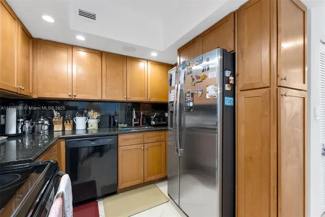 a kitchen with stainless steel appliances granite countertop a refrigerator and a stove