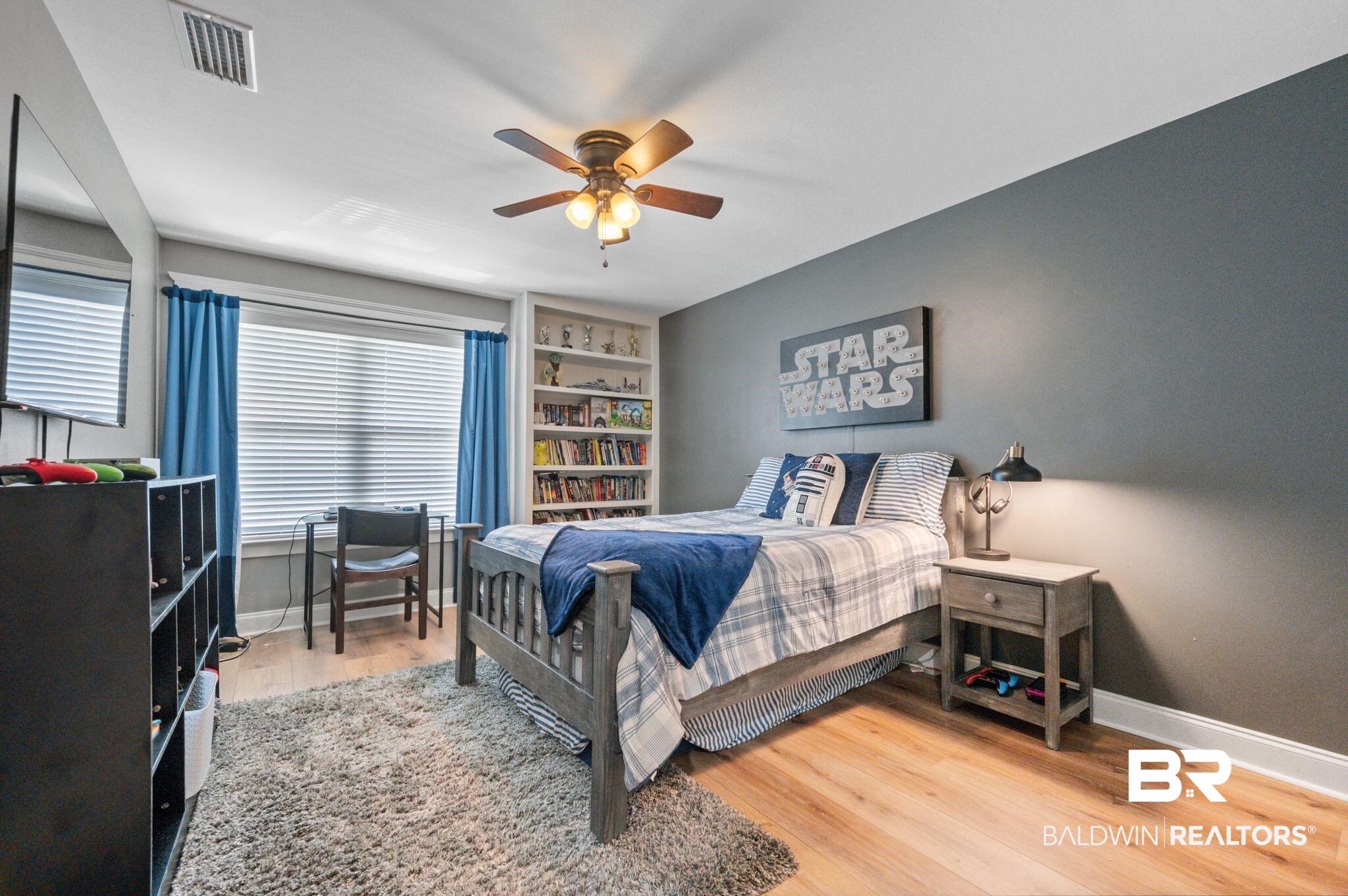 409 Fortune Drive Fairhope, AL 36532 - Photo 27 of 42 Bedroom featuring wood-finish flooring, a built-in shelving unit, a window with horizontal blinds, and a ceiling fan with integrated lighting