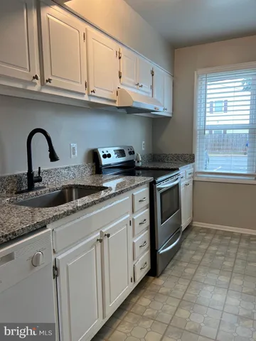 a kitchen with granite countertop a sink stainless steel appliances and cabinets