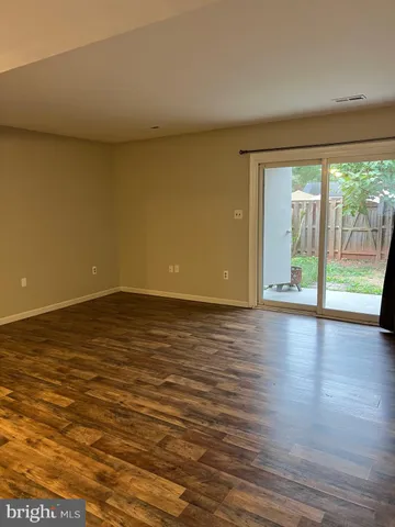 a view of room with wooden floor and floor to ceiling window