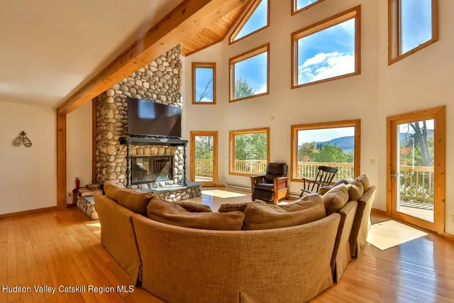 a living room with fireplace furniture and a large window