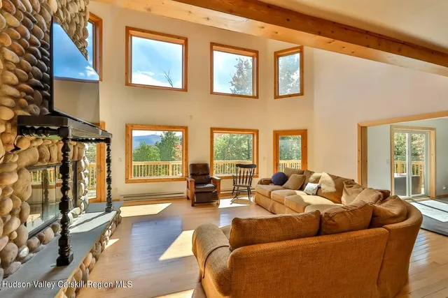a living room with furniture fireplace and large windows