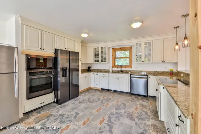 a large kitchen with a stove a refrigerator and a sink